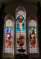 ensemble de trois verrières à personnages : Christ en croix entre saint Jean et Marie en présence de saint Etienne et saint François d'Assise