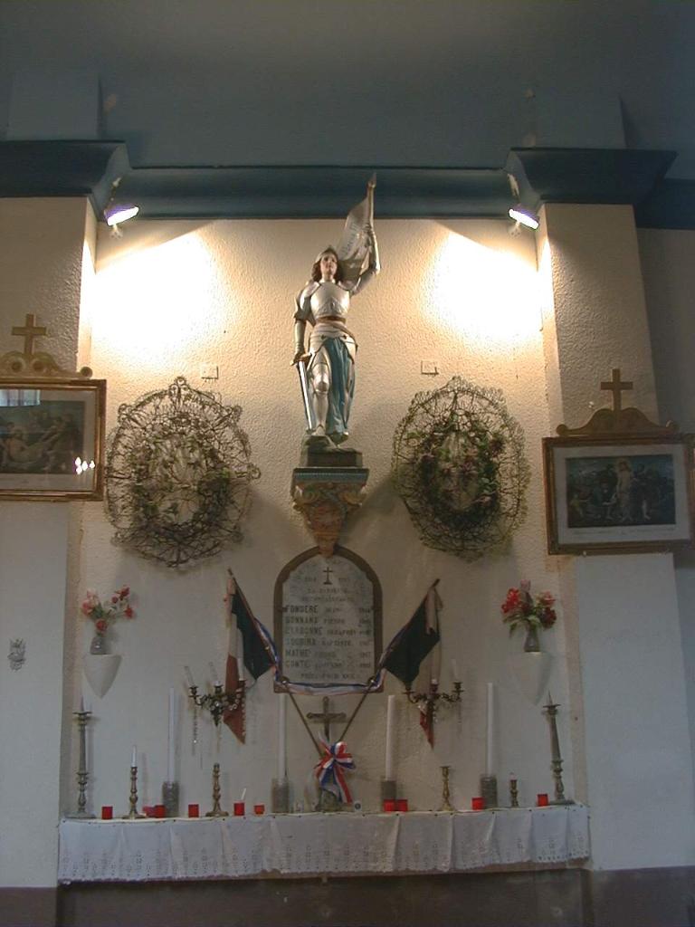 ensemble du monument aux morts de la guerre de 1914-1919 avec la plaque commémorative, les deux drapeaux, les deux couronnes, la statue de Jeanne d'Arc et sa console