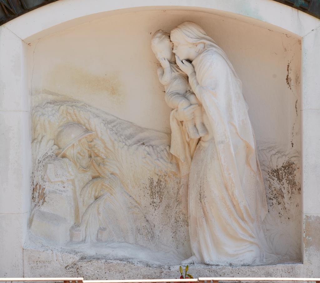 Bas-relief représentant une jeune femme et un enfant devant une croix.